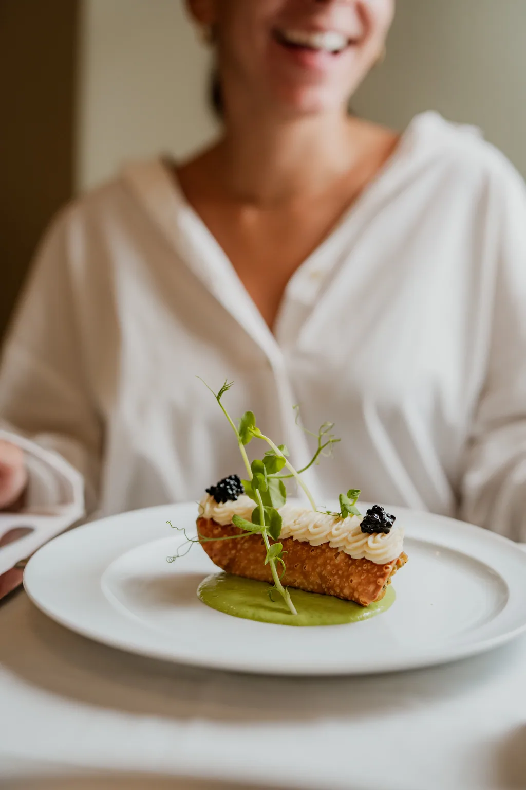 Vegetarischer Cannolo mit Creme und Kaviar auf grünem Coulis