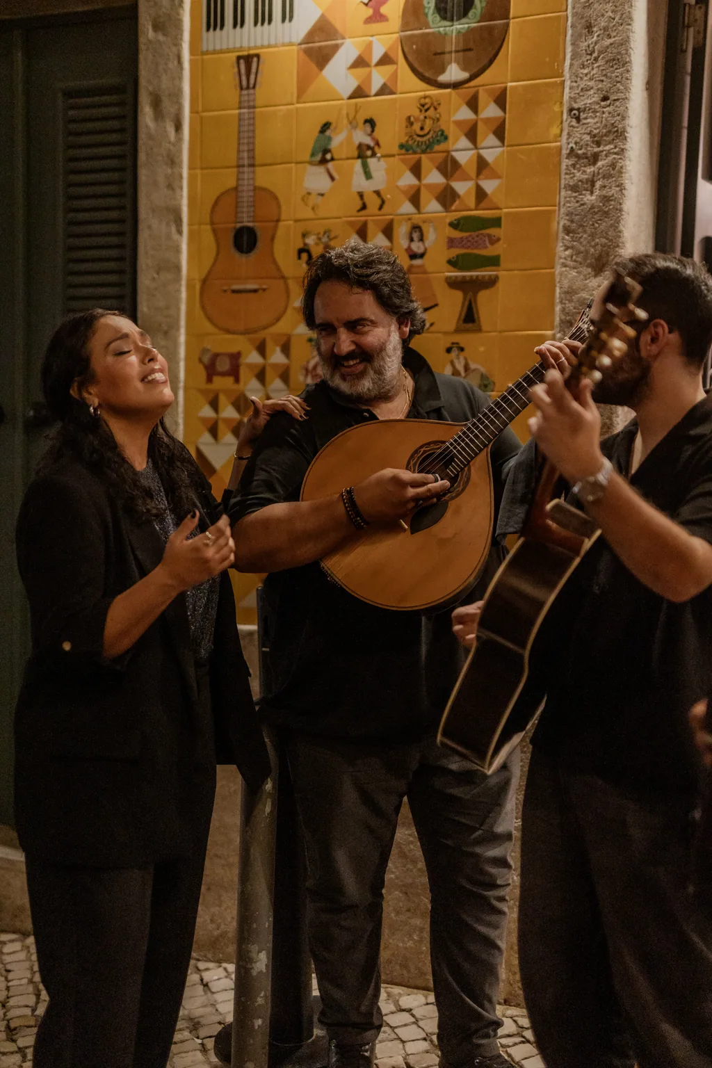Fadista und Gitarrist am Azulejo-Paneel, das dem Fado gewidmet ist