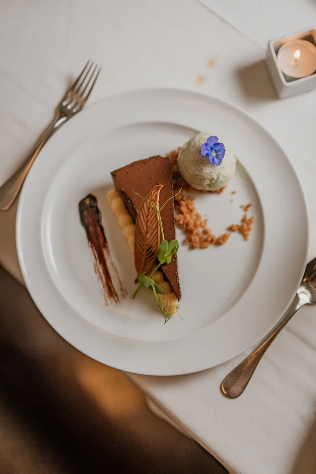Schokoladendessert mit Pistazieneis und essbarer Blüte