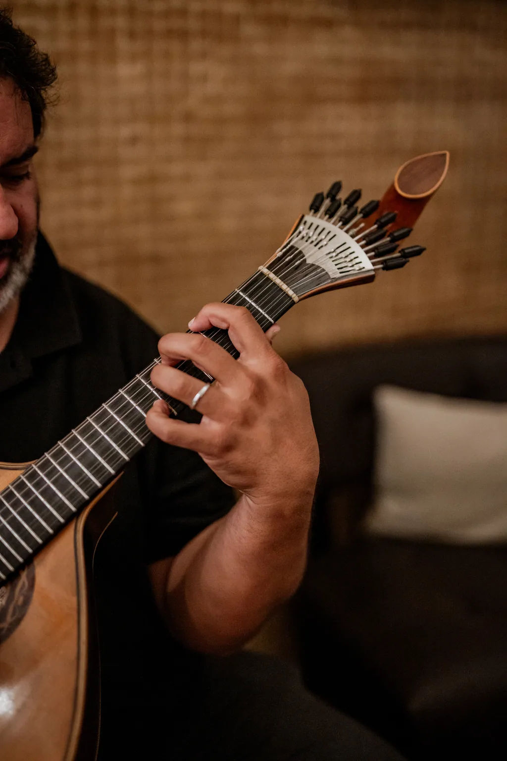 Mãos a tocar guitarra portuguesa em grande plano