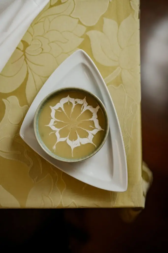 Creme servido em prato triangular sobre toalha amarela na Adega Machado, Lisboa