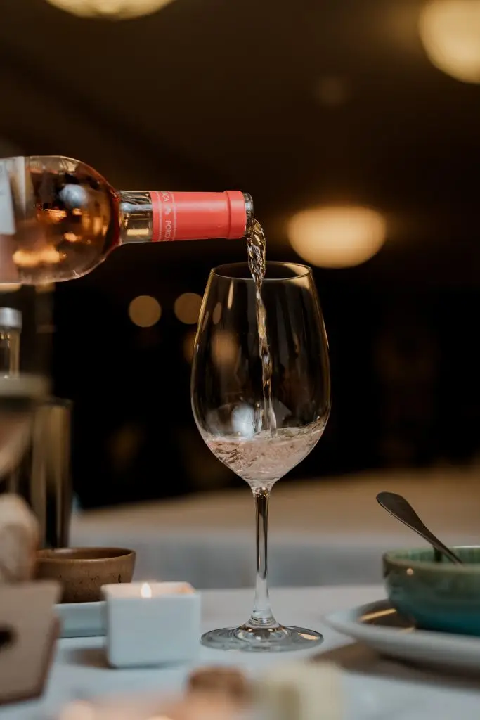 Vinho rosé sendo servido em copo na Adega Machado, casa de fado em Lisboa