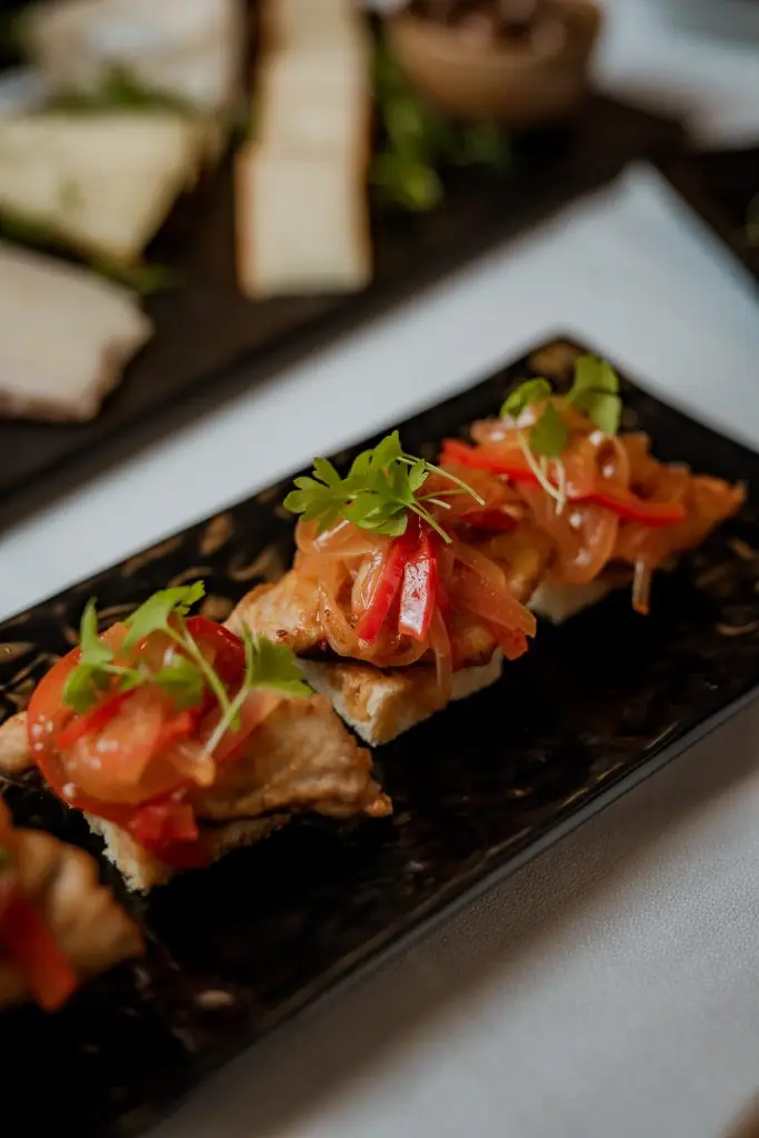Cavala em escabeche com cebola e tomate em bandeja preta na Adega Machado, Lisboa