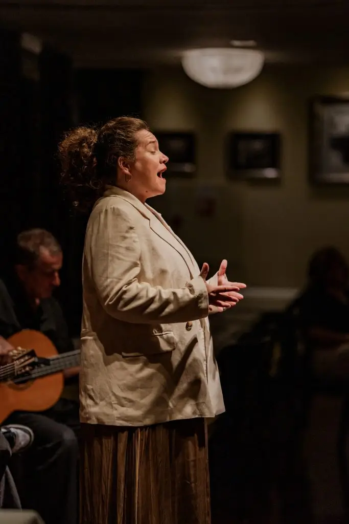 Fadista canta com expressão intensa e olhos fechados durante espectáculo na Adega Machado, casa de fado em Lisboa desde 1937