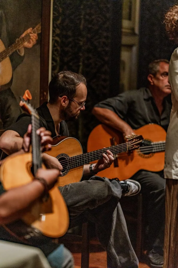 Dois músicos tocam viola e guitarra portuguesa em conjunto na Adega Machado, Bairro Alto, Lisboa