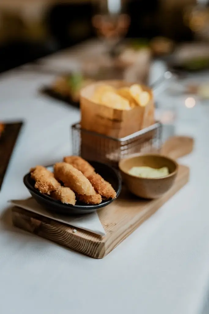 Croquetes dourados servidos com batata frita em saco e maionese na Adega Machado, Lisboa
