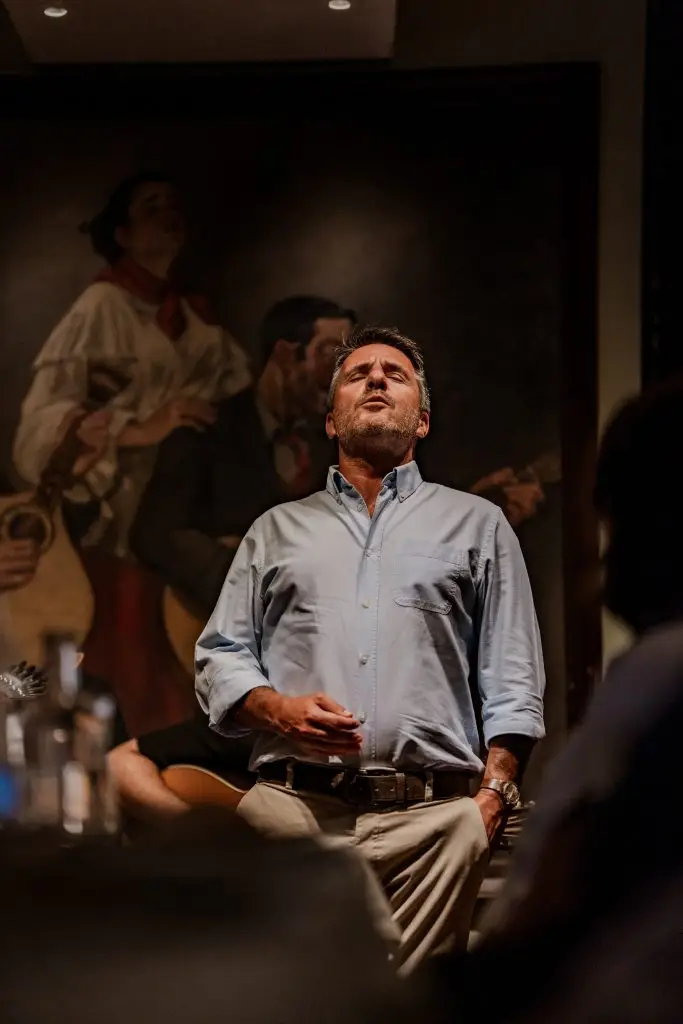 Fadista de camisa azul interpreta um fado com olhos fechados na Adega Machado, Bairro Alto, Lisboa