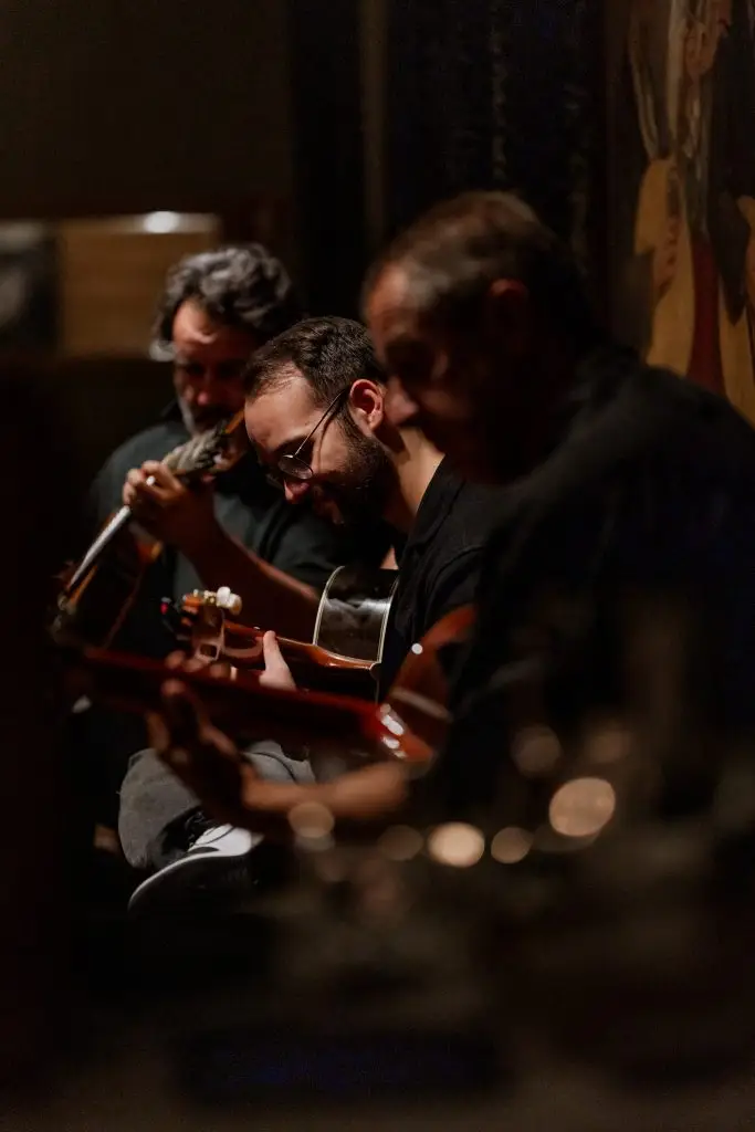 Músico com barba grisalha toca guitarra portuguesa em noite de fado na Adega Machado, Lisboa