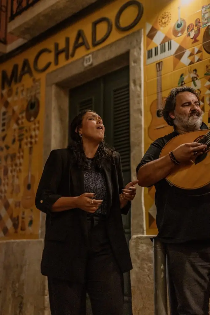 Fachada da Adega Machado iluminada à noite com letreiro neon e janelas de guilhotina, Bairro Alto, Lisboa