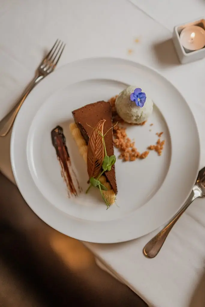 Sobremesa de chocolate com gelado de pistache e flor comestível na Adega Machado, Lisboa