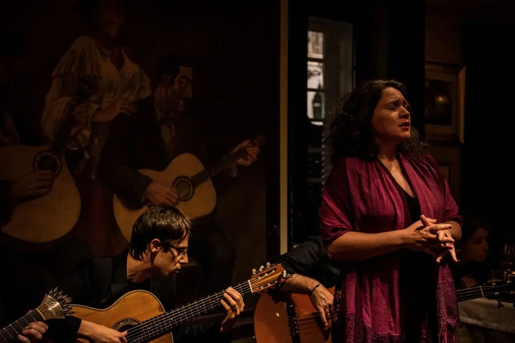 Fadista a cantar acompanhada por guitarra portuguesa e viola no palco da Adega Machado, Bairro Alto, Lisboa